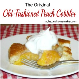 Piece of Peach Cobbler Topped with Whip Cream on White Plate with Fork on Red and White Tablecloth, Original Old-Fashioned Peach Cobbler
